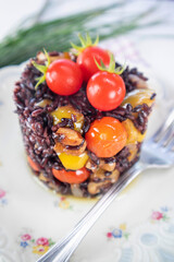 Black risotto with tomatoes peppers and walnuts
