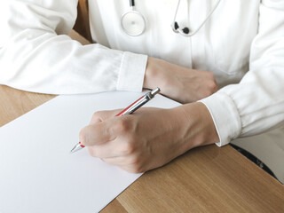 Doctor writing on a clipboard in medical office