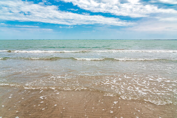 Fototapeta na wymiar Empty sandy sea beach with small waves