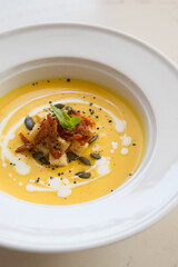 Fresh yellow pumpkin soup served with croutons