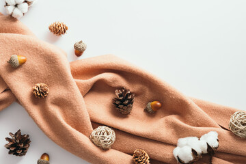 Autumn flat lay composition with brown scarf, pine cones, cotton, acorns on white background. Top...