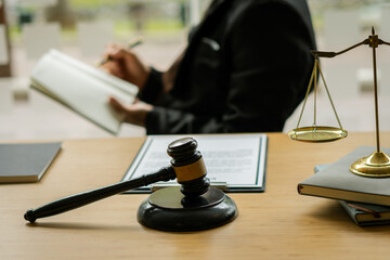 Male lawyer working at a desk in the office Highlight the scales of justice and the hammer of the...