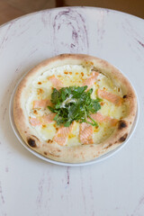 Seafood salmon pizza with arugula and cheese