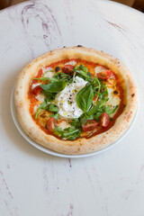 Buratta cheese on a neapolitan pizza on a table
