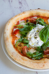 Buratta cheese on a neapolitan pizza on a table