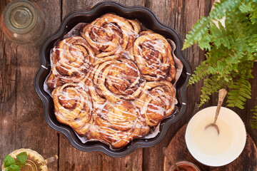 Rose cinnamon rolls. Brioche. Top view, wooden background, icing sugar, cocoa, yeast buns.