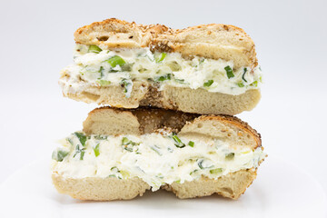 A Cut in Half and Stacked New York Style Sesame Seed Bagel filled with Scallion Cream Cheese