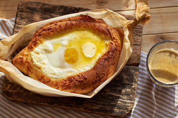 Adjaruli (Acharuli) Khachapuri, Georgian cheese bread. Traditional Georgian recipe made with a bread dough, filled with cheese and crowned with an egg and a butter. 