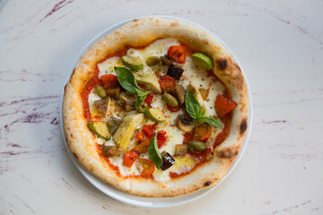 Baked neapolitan pizza with artichokes on a cafe table