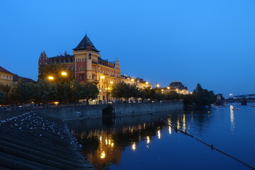 Naklejka premium sunset and night view near Charles Bridge with river view and reflection, a medieval stone arch bridge that crosses the Vltava (Moldau) river, Prague, Czech Republic