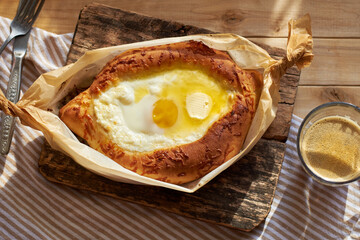 Adjaruli (Acharuli) Khachapuri, Georgian cheese bread. Traditional Georgian recipe made with a bread dough, filled with cheese and crowned with an egg and a butter. 