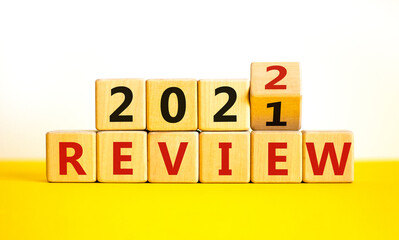 2022 review new year symbol. Turned a wooden cube and changed words 'Review 2021' to 'Review 2022'. Beautiful white background, copy space. Business, 2022 review new year concept.