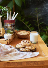 Oatmeal Chocolate Chip Cookies. Wooden table, side view, milk, chocolate, oatmeal.