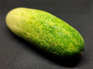 fresh green cucumber on black background