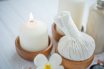 Natural relaxing spa composition on massage table in wellness center    with towels, flowers and salt, candle  on massage table in spa salon.