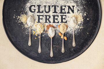 Gluten free written in flour on vintage baking sheet and spoons of various gluten free flour...