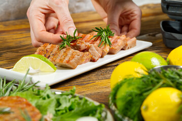 Obraz na płótnie Canvas Chef hands decorating sliced fried yellow tuna fish with vegetables. blue tuna steak