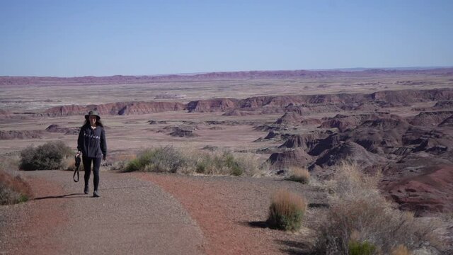 Female Landscape Photographer on Desert HIking Trail, Petrified Forest National Park, Arizona USA, Full Frame Slow Motion