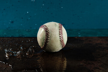 Old used baseball in water shows wet ball for game.