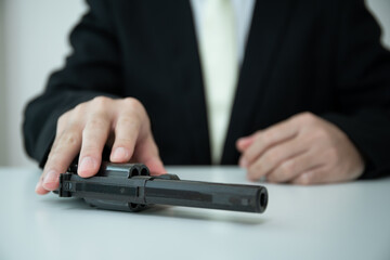 Unrecognizable Asian businessman draw the gun from gun holder inside his suit close up. 