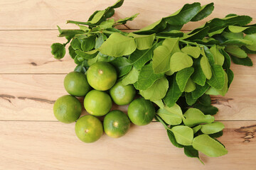 Lemons, Fresh Citrus hystrix fruits, vegetables, and herbs isolated on wooden background closeup.