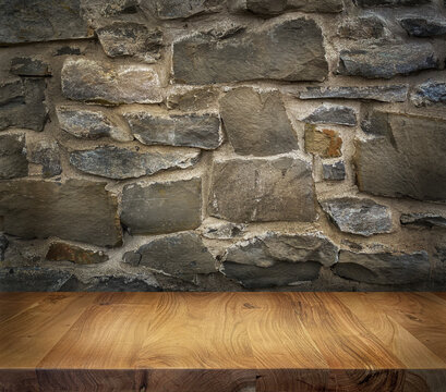 Wooden table top with stonewall background texture. Place for product.