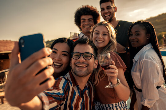 Group of friends at reunion making selfie outdoor.
