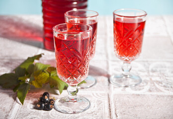 glasses of black currant brandy liqueur with ripe berries