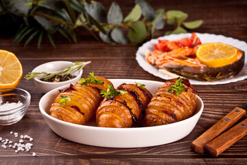 American traditional homemade Hasselback Potato and stuffed potatoes with fresh herbs and bacon.