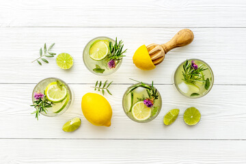 Fresh cold beverage with summer herbs and lemon in glasses