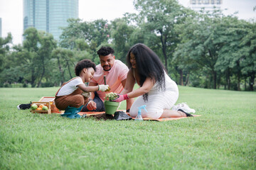 Happy African family picnic and doing activities together in park on vacation. Little son and his...