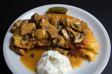 Potato dish with sour cream and sauce. Delicious. Dish on a plate. Background.