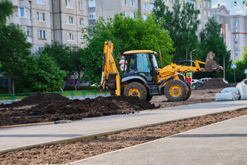 Yellow tractor repairs the road. Russia, Vladimir, 02.06.2021. Road works in the city. Industrial Equipment. High quality photo