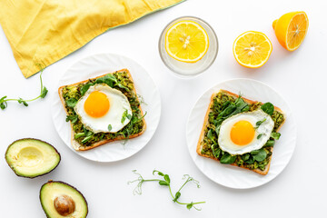 Breakfast with avocado toasts and fried eggs, top view