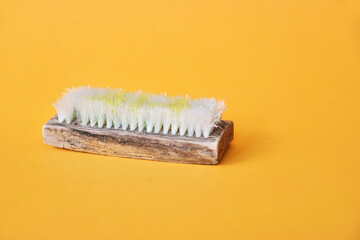 Washing brush in used condition on yellow background