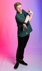 portrait of a red-haired guy in a green shirt and jeans on a colored background. the teenager...