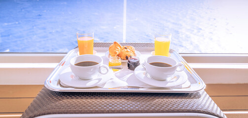 Tasses de café et petit déjeuner sur la terrasse d'une cabine balcon d'un navire de croisière,...