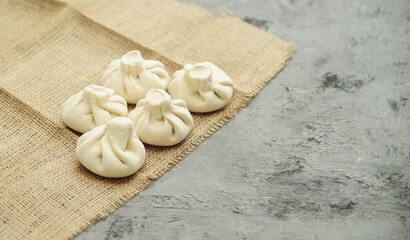 Frozen khinkali on stone background. National georgian food.