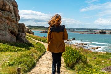 A young woman walking along the paths of the beautiful coastline at low tide of Le Gouffre de...