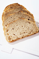 Pieces of bread on a cutting board top view on white clean plastic cutting board