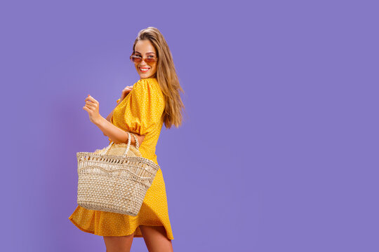 Fashionable woman in nice yellow dress and straw handbag. Fashion spring summer photo