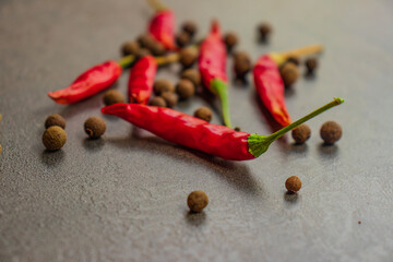 Hot peppers with spices on wooden table close up