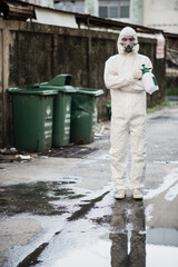 Disinfection specialist in PPE suit performing spray public decontamination