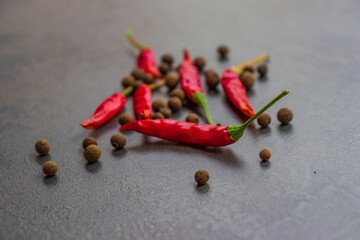 Hot peppers with spices on wooden table close up