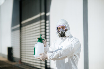 Disinfection specialist in PPE suit performing public decontamination