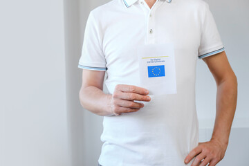 Unrecognized Vaccinated Male Showing Real Paper EU Digital COVID Certificate. Coronavirus Vaccination Advertisement Campaign. Vaccine Done