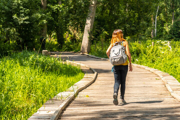 A young woman on the footpath along a footbridge between La Garette and Coulon, Marais Poitevin the Green Venice, near the town of Niort, France