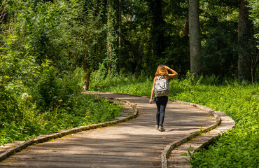 A young woman walking on the trek on the trail between La Garette and Coulon, Marais Poitevin the Green Venice, near the town of Niort, France