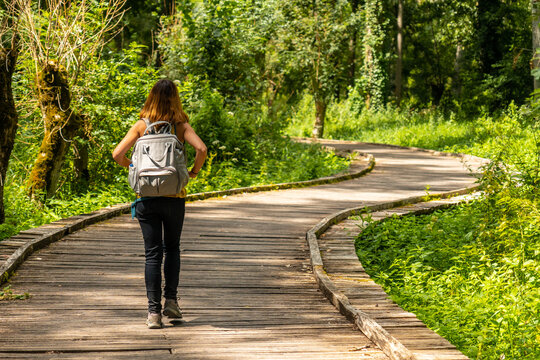 A young woman walking on the trek on the trail between La Garette and Coulon, Marais Poitevin the Green Venice, near the town of Niort, France