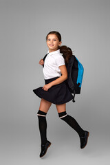 cute happy schoolgirl jumping up with backpack